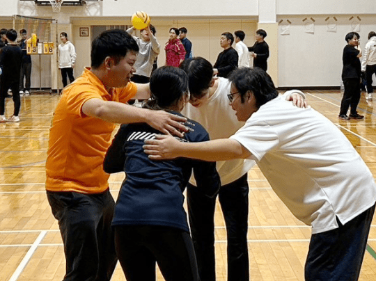 バレーボールイベントの最中、チームが一体感を高めるために円陣を組んでいる